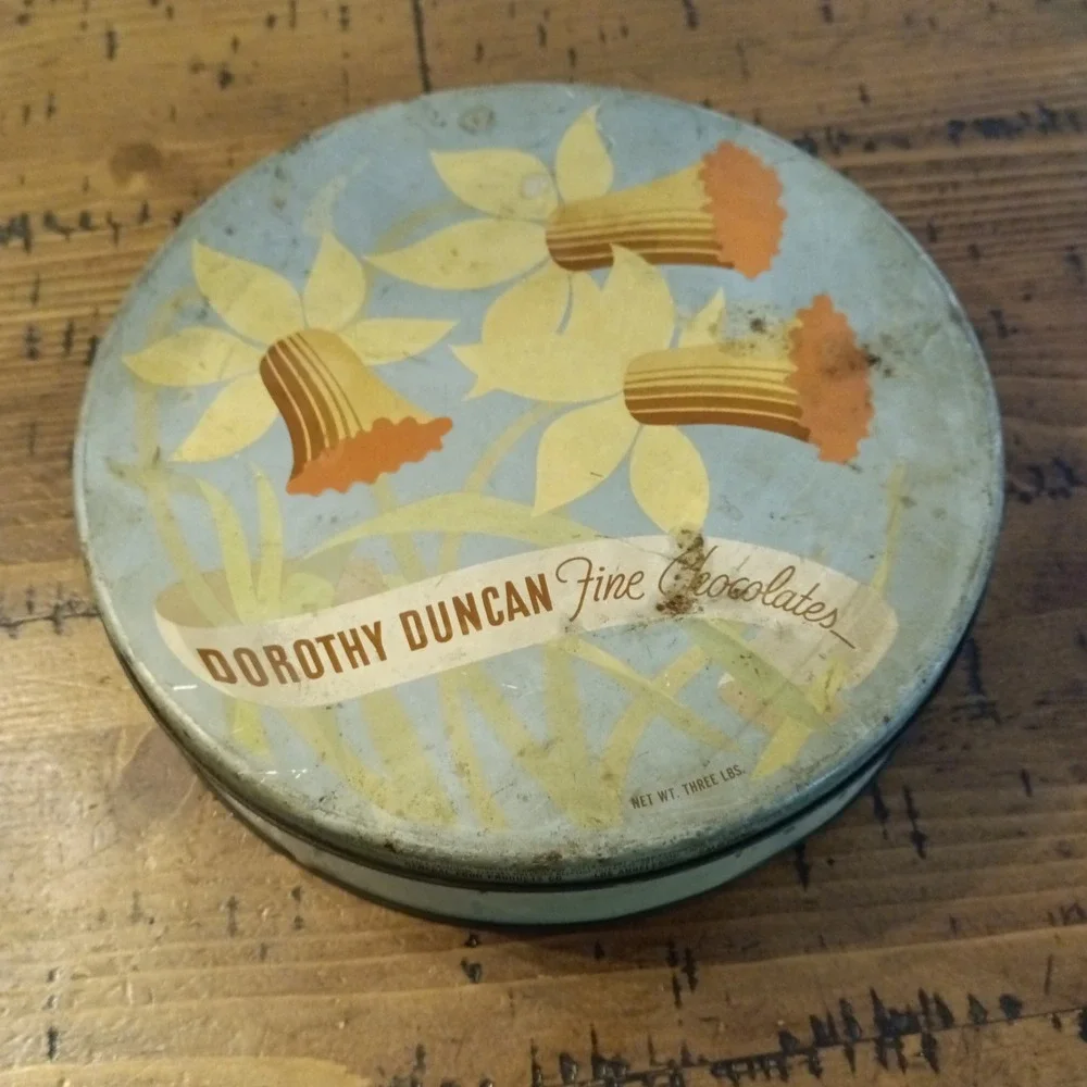 Vintage Dorothy Duncan Fine Chocolates Tin Daffodil Floral 10 Inch Round Metal